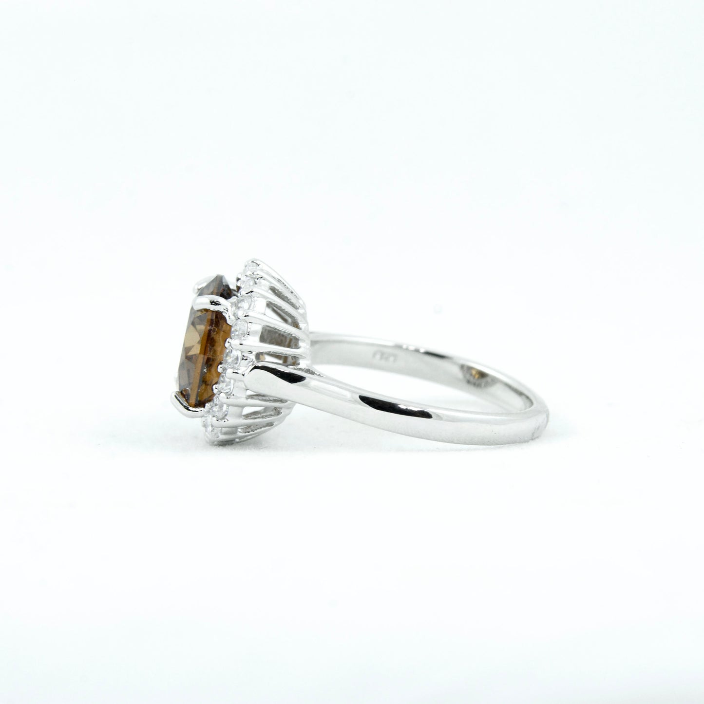 Non-tarnishing, rhodium plated, 925 sterling silver ring. Features a large coffee coloured round-cut centre AAA quality cubic zirconia stone surrounded by a halo of small clear cubic zirconia stones. Centre stone comes in two colours: black and coffee. Available in sizes 5, 6, 7, 8, and 9.