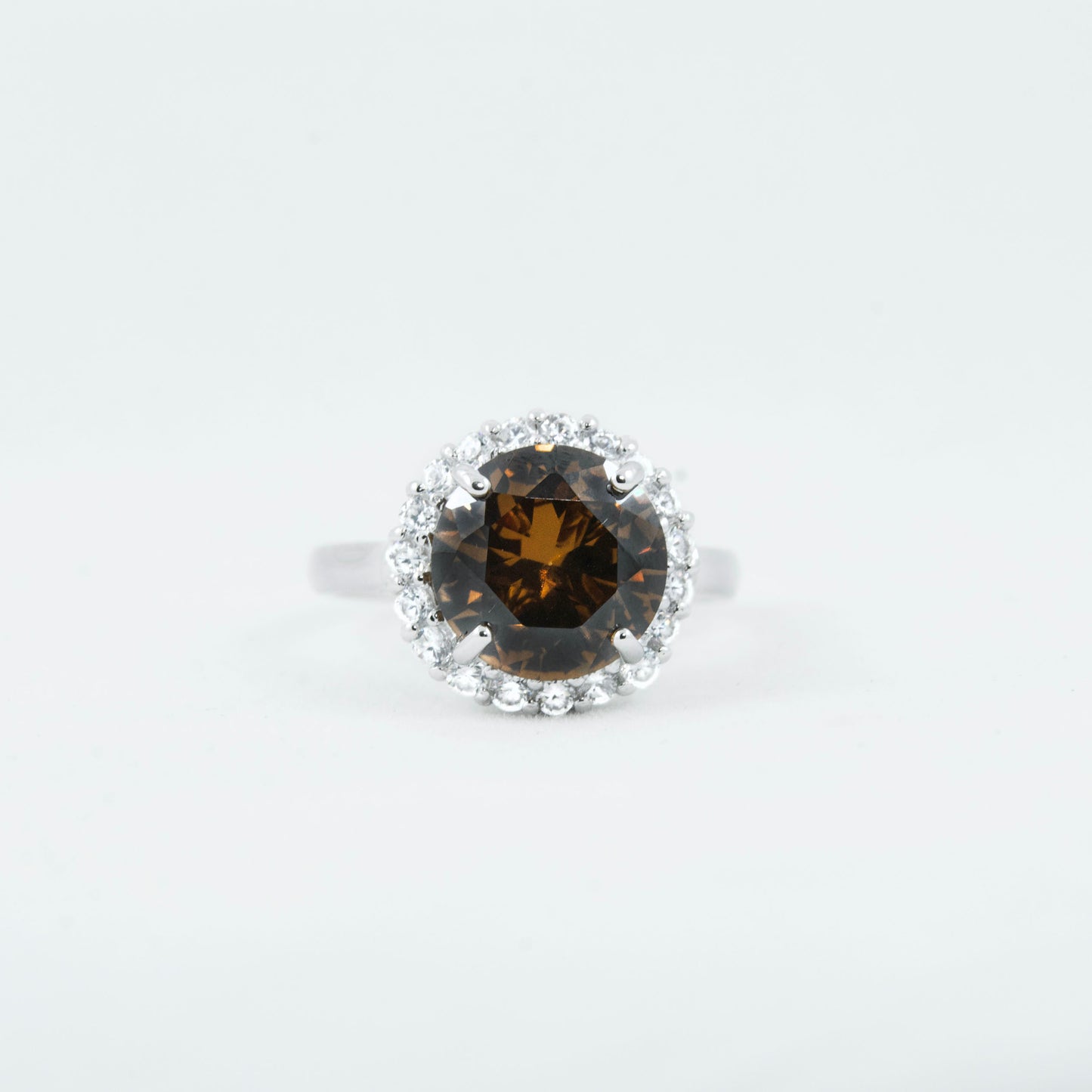 Non-tarnishing, rhodium plated, 925 sterling silver ring. Features a large coffee coloured round-cut centre AAA quality cubic zirconia stone surrounded by a halo of small clear cubic zirconia stones. Centre stone comes in two colours: black and coffee. Available in sizes 5, 6, 7, 8, and 9.